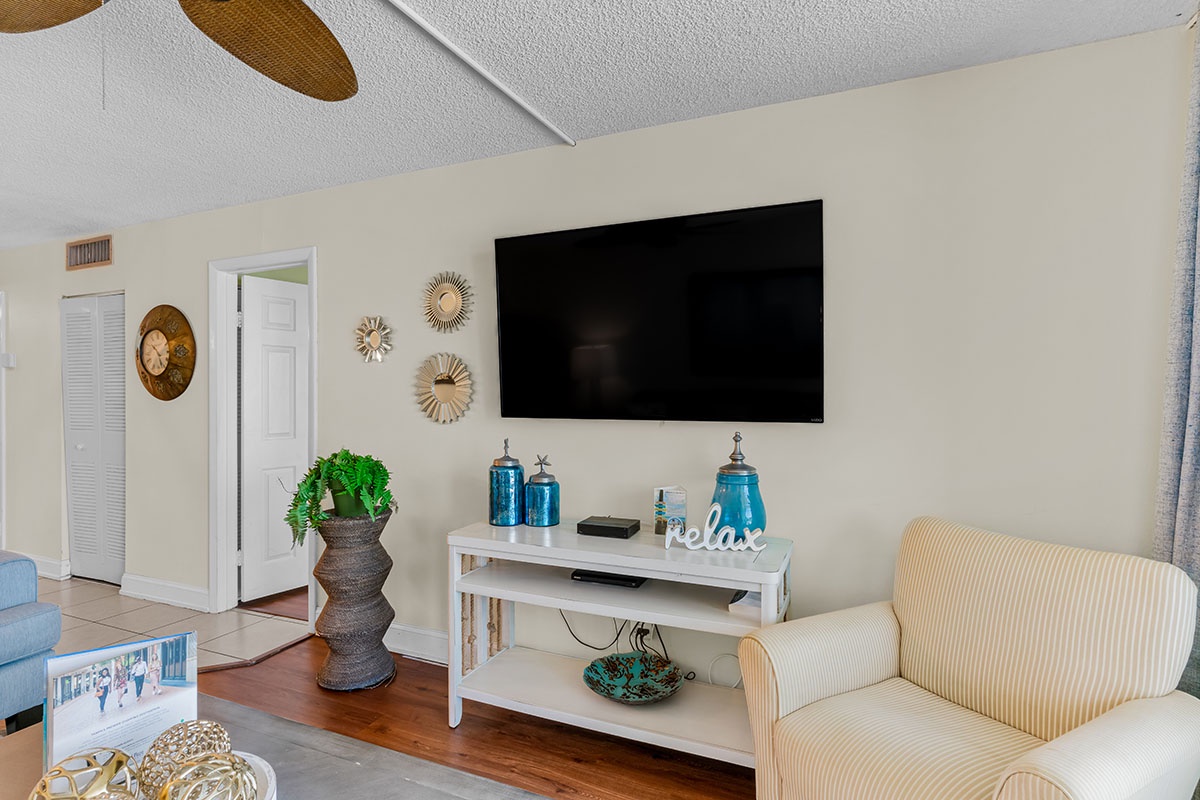 Settle into your cozy living space with warm coastal touches, a large TV for movie nights, and comfortable seating perfect for relaxing.