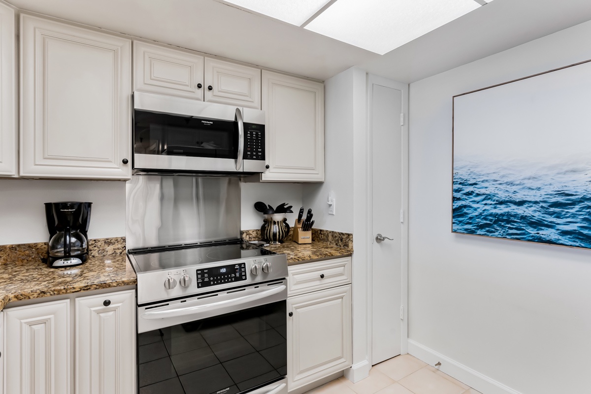 Step into your fully equipped kitchen, where natural light pours through the skylight and everything you need is at your fingertips—from the stainless steel appliances to the granite countertops.
