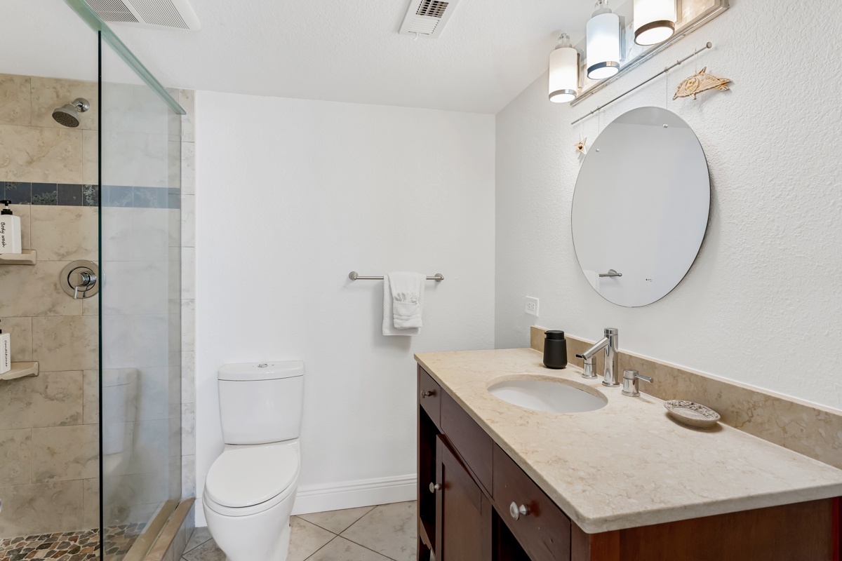 Step into your elegant bathroom featuring natural stone finishes, spacious glass shower, and thoughtful amenities for a luxurious retreat.