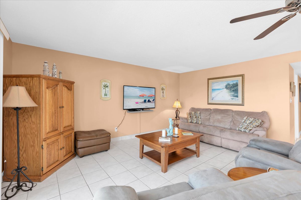 Settle into this inviting living room, where plush seating and coastal decor invite you to unwind after your beach adventures. The ceiling fan keeps you cool while you enjoy your favorite shows.