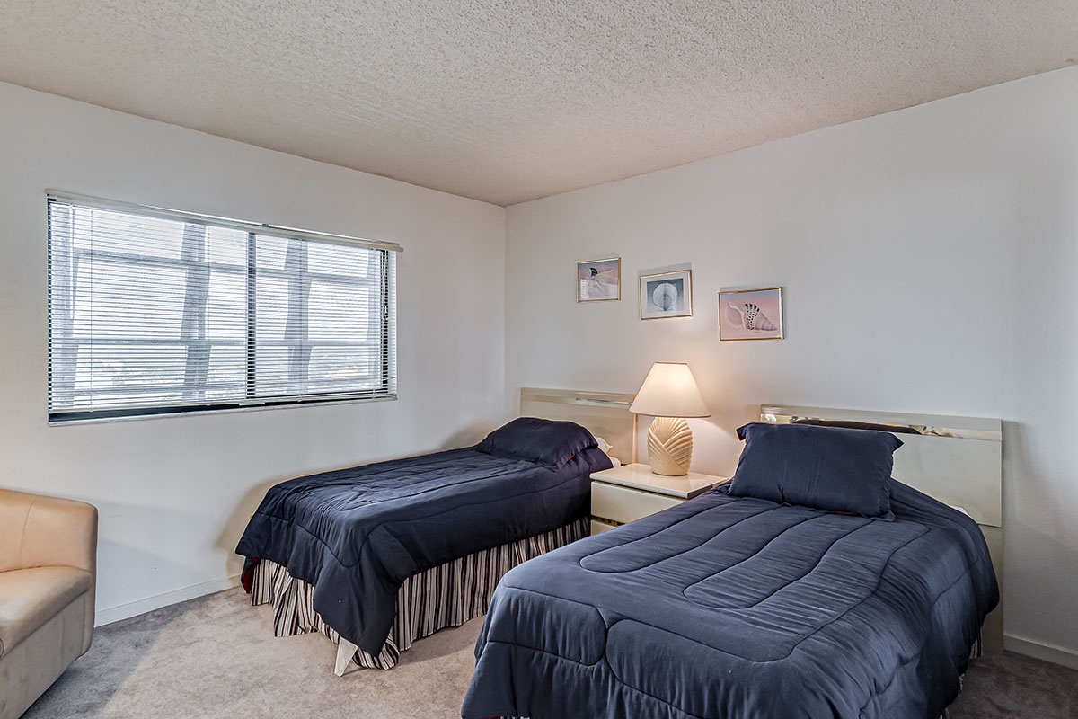 Rest comfortably in your twin bedroom with natural light and cozy seating area for a perfect night's sleep.