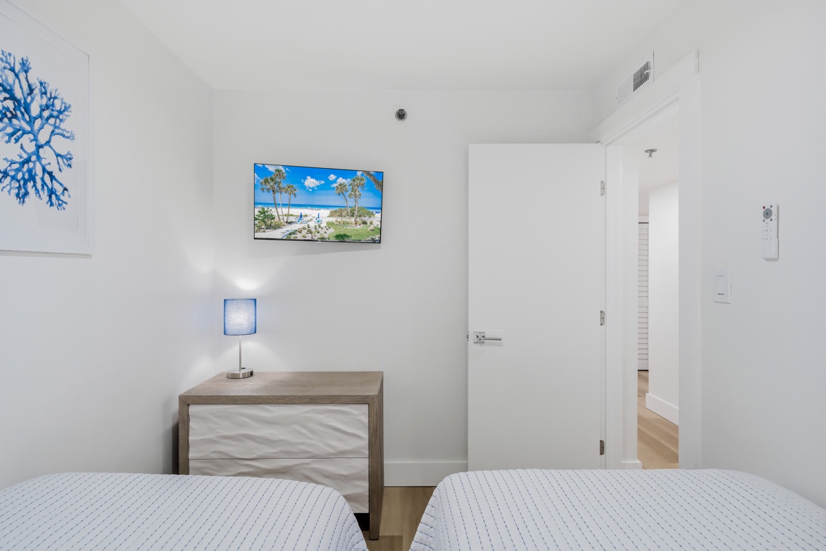 Your peaceful bedroom retreat features coastal-themed artwork and a wall-mounted TV for cozy evenings in.