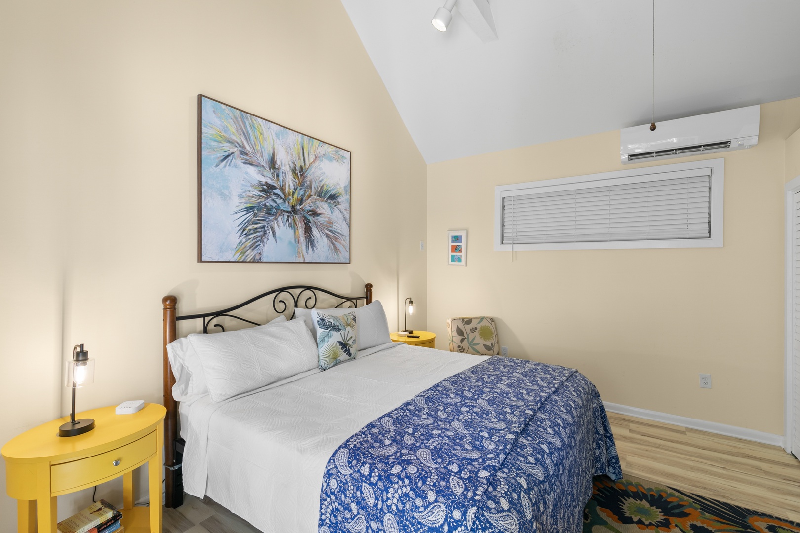 Settle into your bright and airy bedroom, where coastal charm meets comfort. The vaulted ceiling and soft yellow accents create a warm, inviting retreat perfect for restful nights.