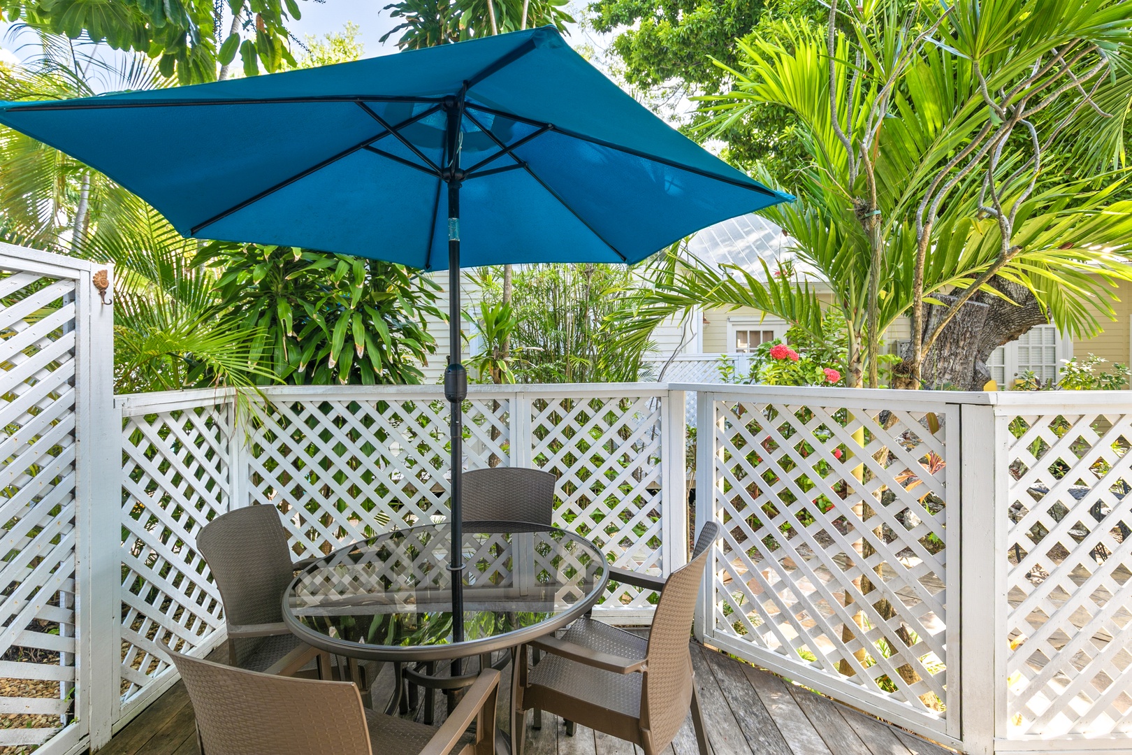 A charming private patio surrounded by lush tropical palms, where you can enjoy morning coffee or evening cocktails beneath the shade of your own umbrella.