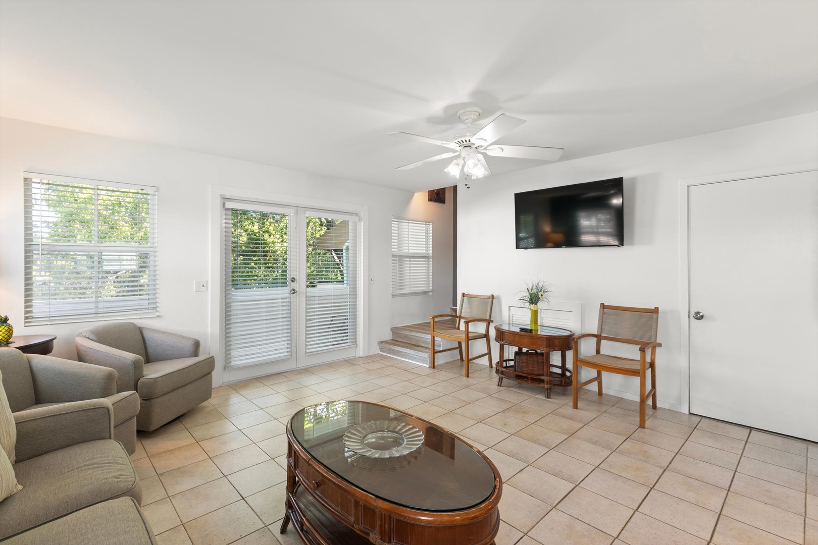 Gather around the small café table in this open-plan living space, where cheerful pops of teal and sunny yellow add a playful touch. A ceiling fan keeps you cool while you unwind in this bright, casual retreat.