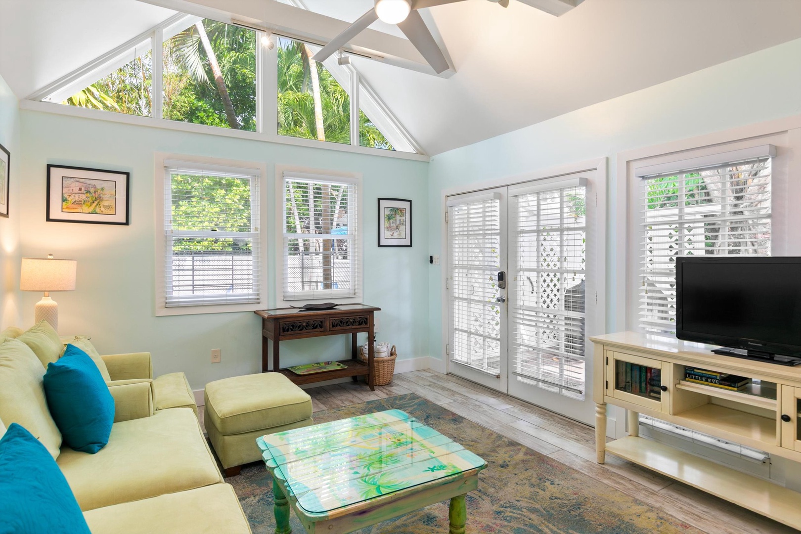 Sink into the comfy sofa and soak in the airy, light-filled space with vaulted ceilings, tropical garden views, and your private patio just steps away—a serene retreat for unwinding.