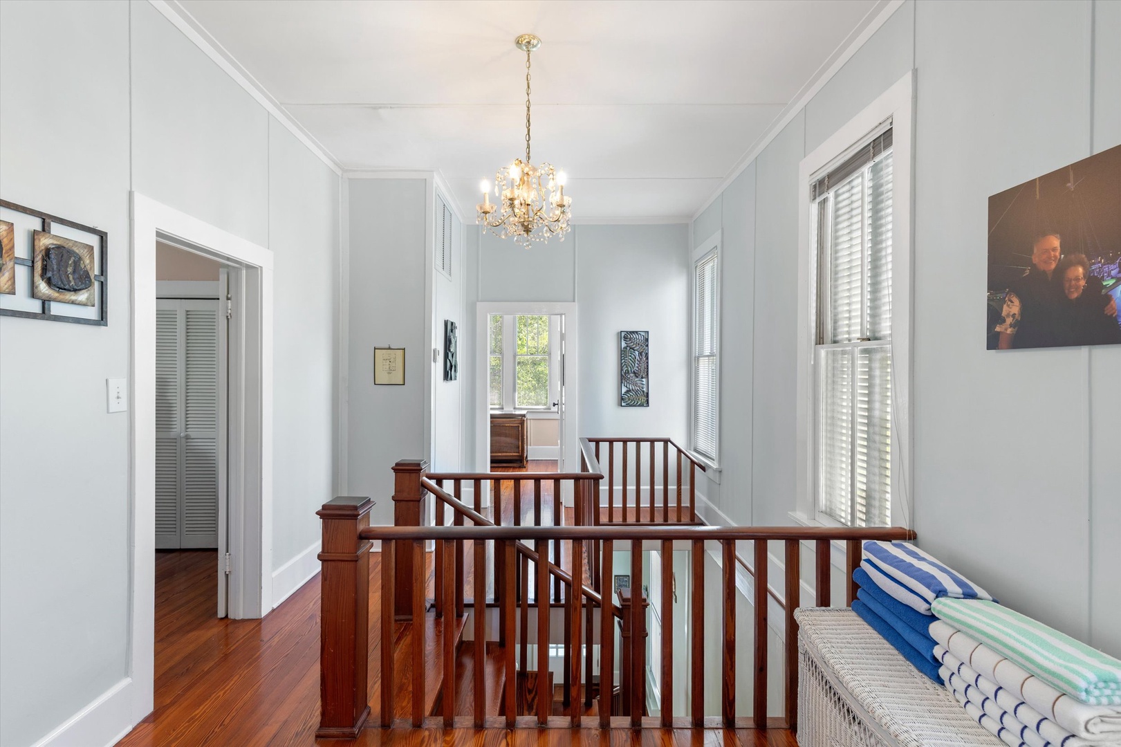 Sunlight spills through tall windows onto warm timber floors, where a classic chandelier and inviting seating area create your perfect retreat between adventures.
