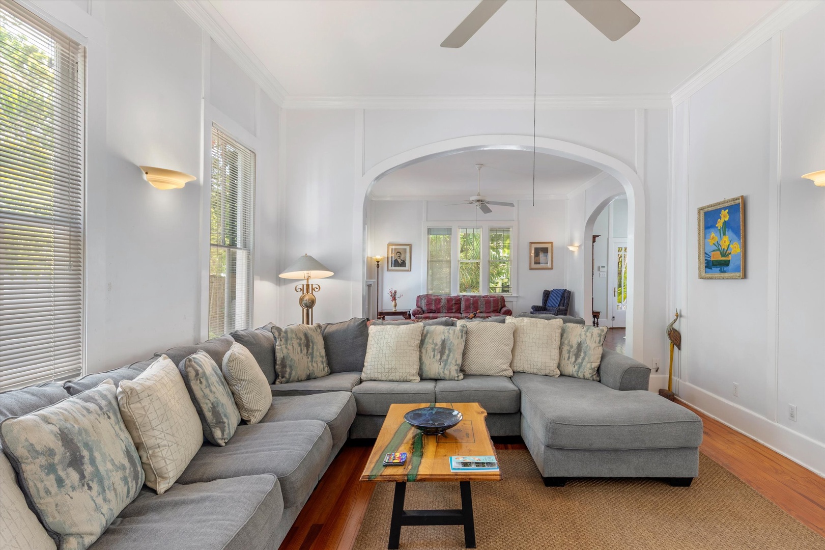 Sink into the spacious sectional sofa in your airy, light-filled living room. High ceilings, elegant archways, and polished wood floors create a refined yet comfortable retreat for relaxation.