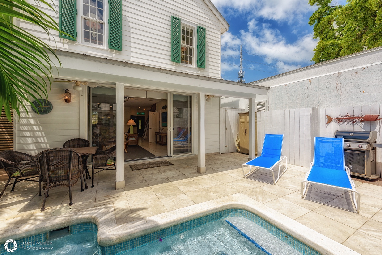 Private back patio with covered seating area, lounge chairs and pool