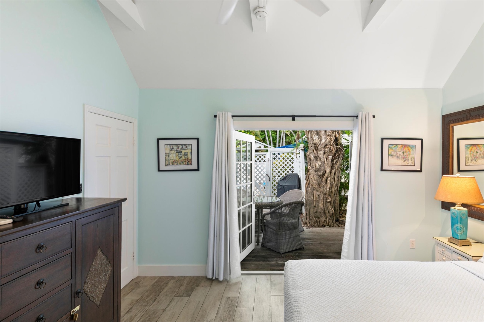 Step into your serene retreat with calming coastal blue walls and vaulted ceilings. Through the private patio doors, your own secluded outdoor nook awaits beneath the shade of a mature tree.
