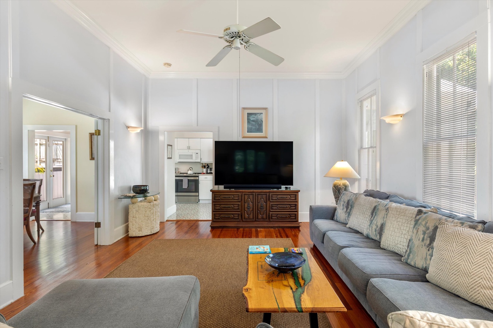 Unwind in your spacious living room featuring gleaming hardwood floors, vaulted ceilings with a fan, and plush seating perfect for gathering with loved ones after exploring.