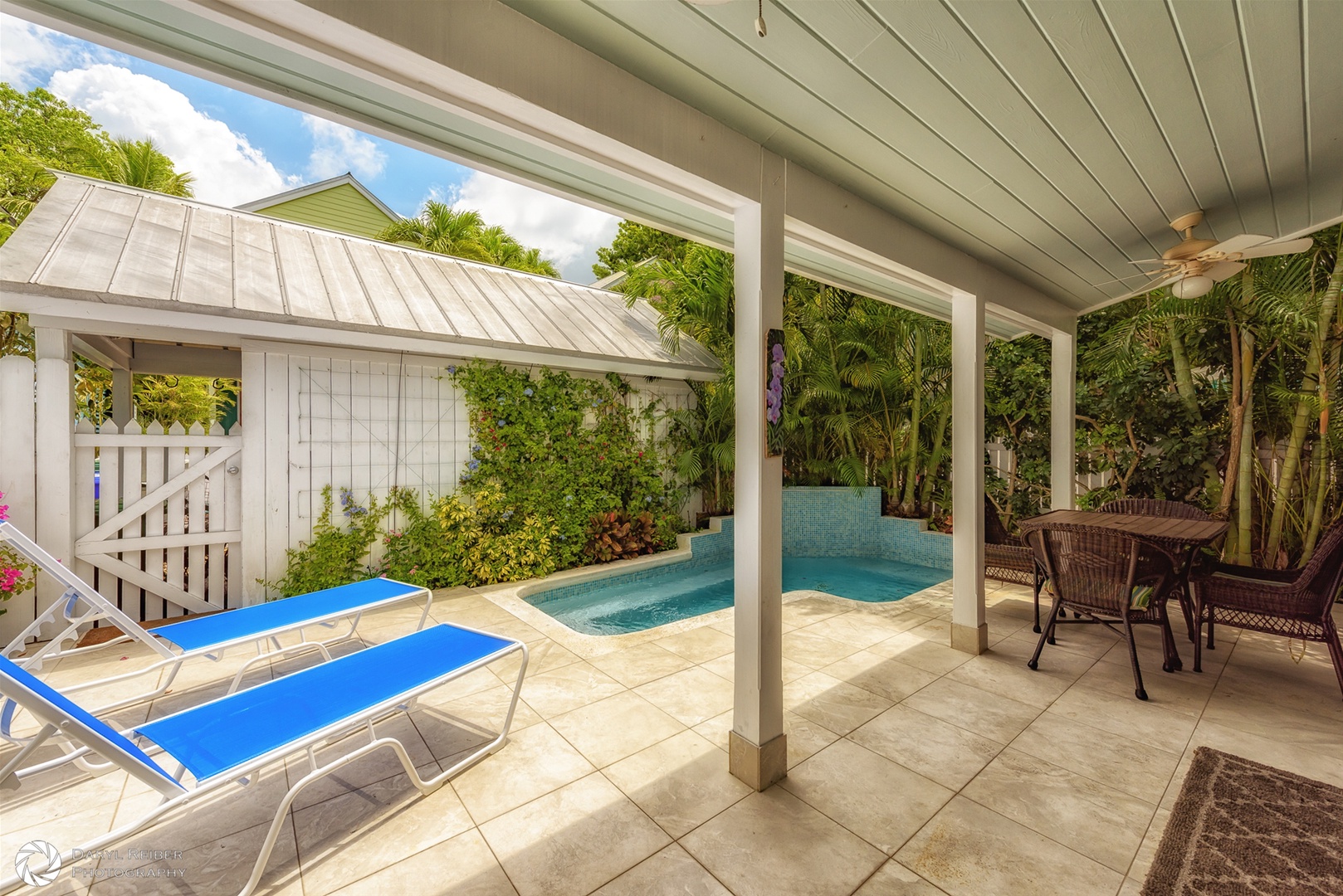 Private back patio with covered seating area, lounge chairs and pool