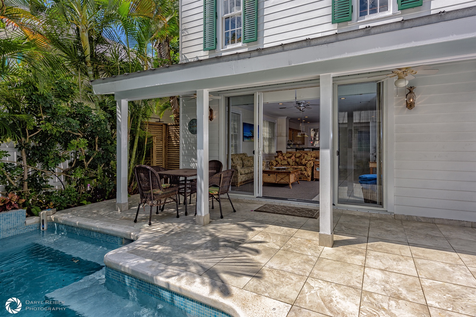 Private back patio with covered seating area, lounge chairs and pool
