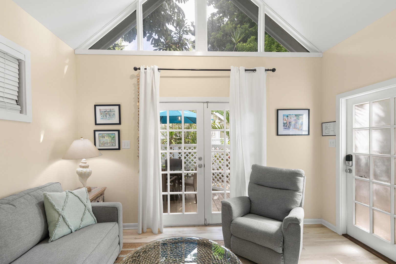 Step into your bright, airy living space where vaulted ceilings and French doors frame stunning ocean views, inviting you to relax in comfort and style.