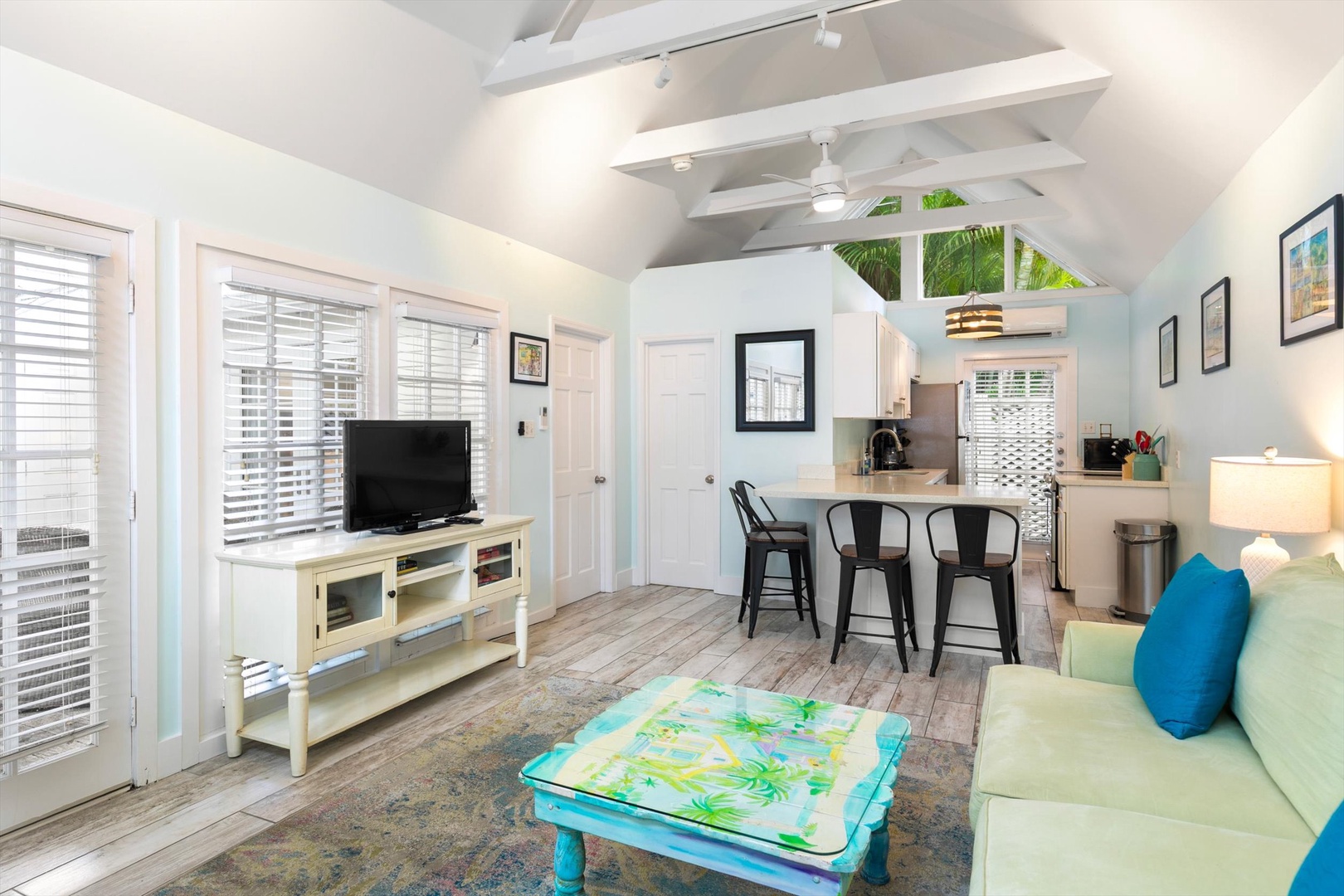 Step into your breezy island retreat, where vaulted ceilings with classic white beams and soft tropical hues invite you to truly unwind. Palm fronds peek through the windows, wrapping you in coastal charm.
