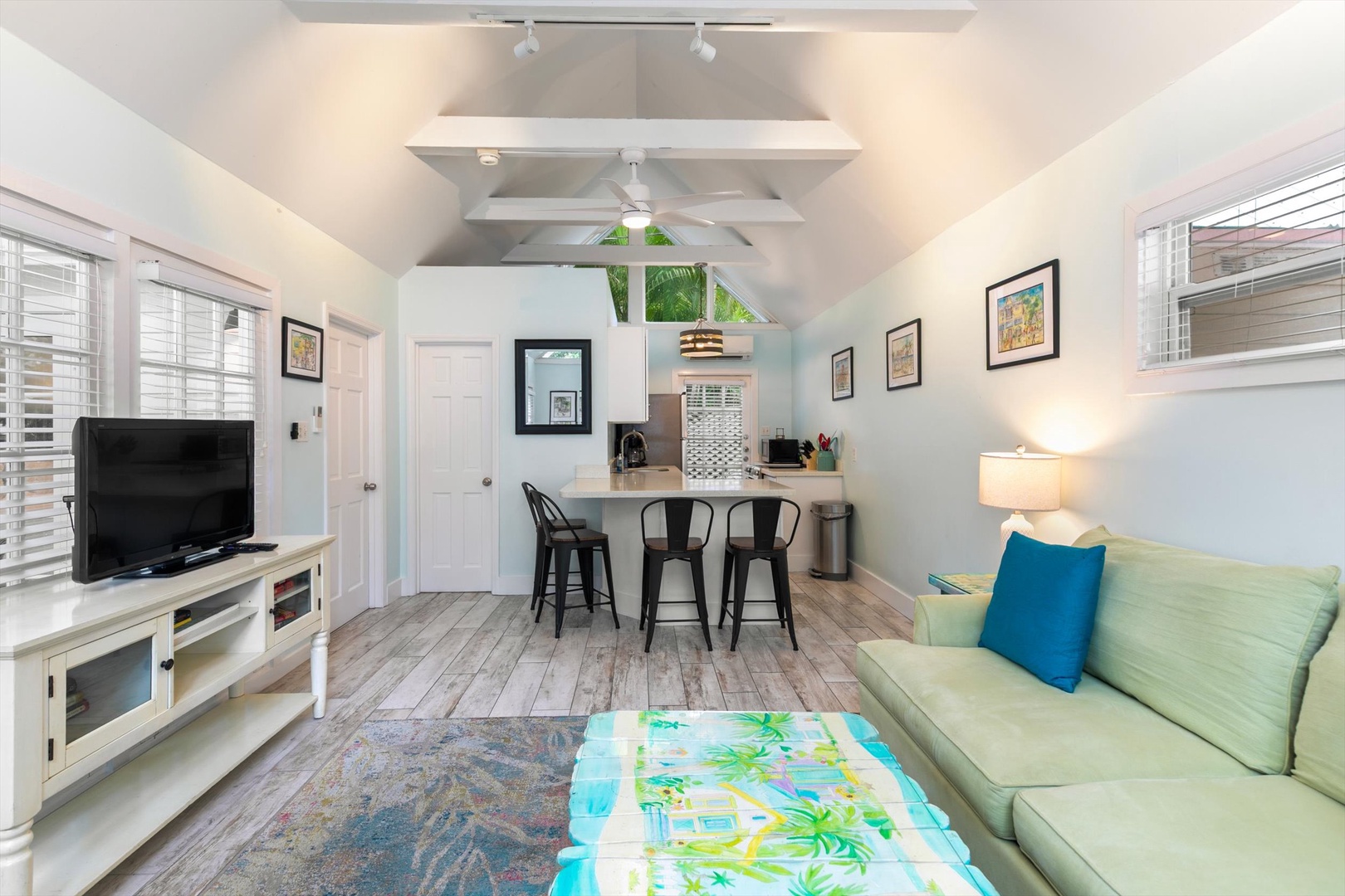 Relax in your bright, open-plan retreat with vaulted ceilings and cheerful tropical touches. The living room flows seamlessly into a kitchenette and dining space, perfect for unwinding after beach adventures.