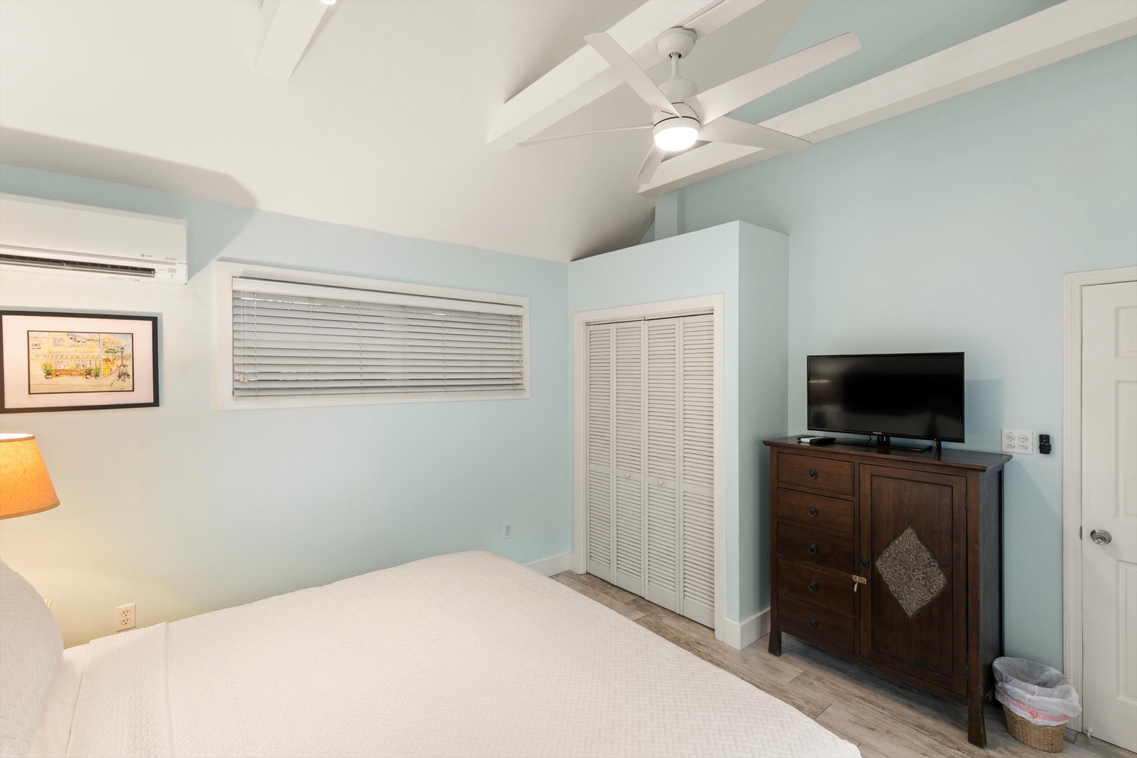 Your serene bedroom sanctuary awaits, with soothing blue walls, vaulted ceilings, and peaceful coastal vibes. Ceiling fan and AC keep you comfortable, while ample closet space holds all your vacation gear.