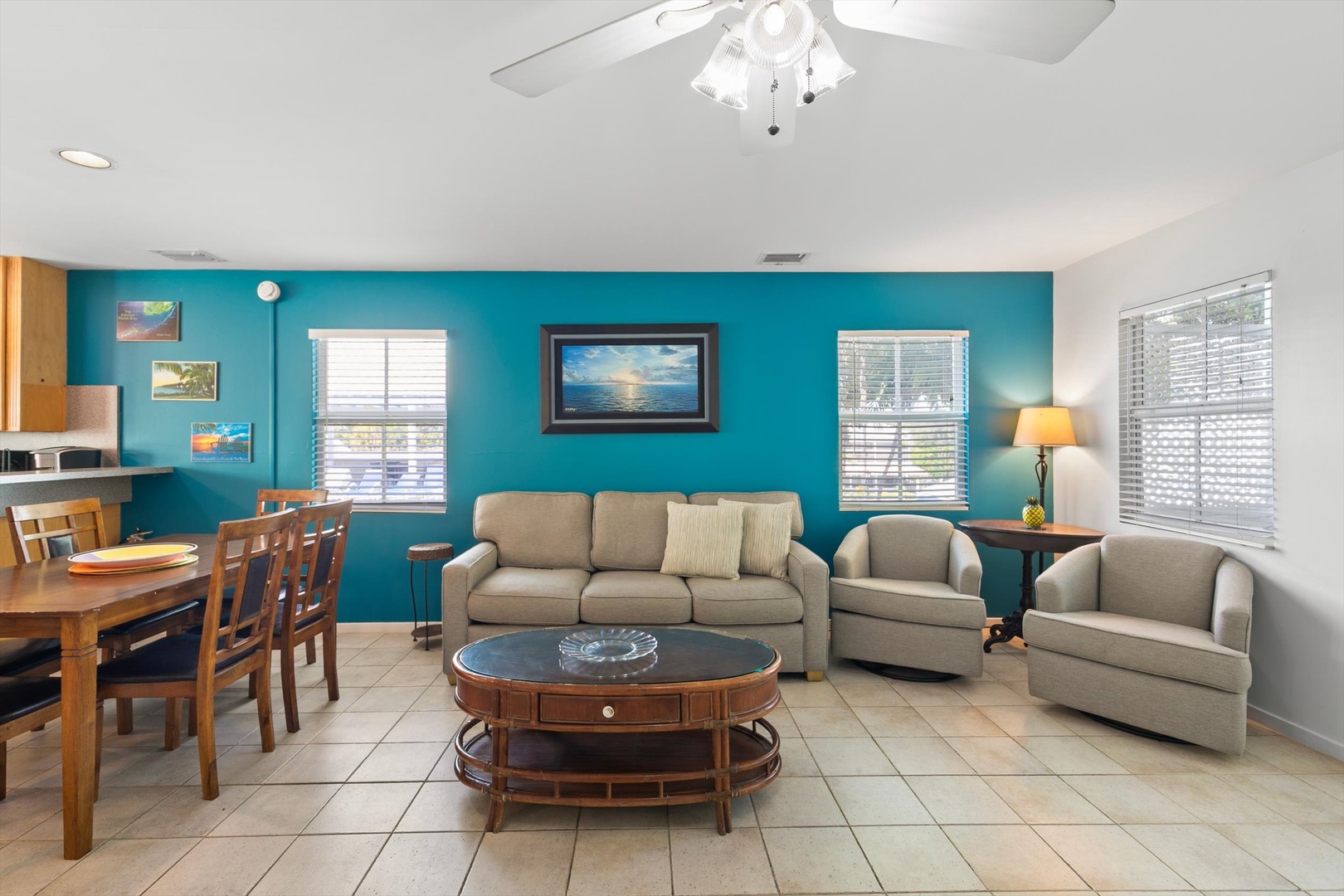 Settle into your comfortable living space, where bold turquoise walls and soft neutral furnishings create an inviting retreat. Sink into the cozy couch and unwind after your beach adventures.