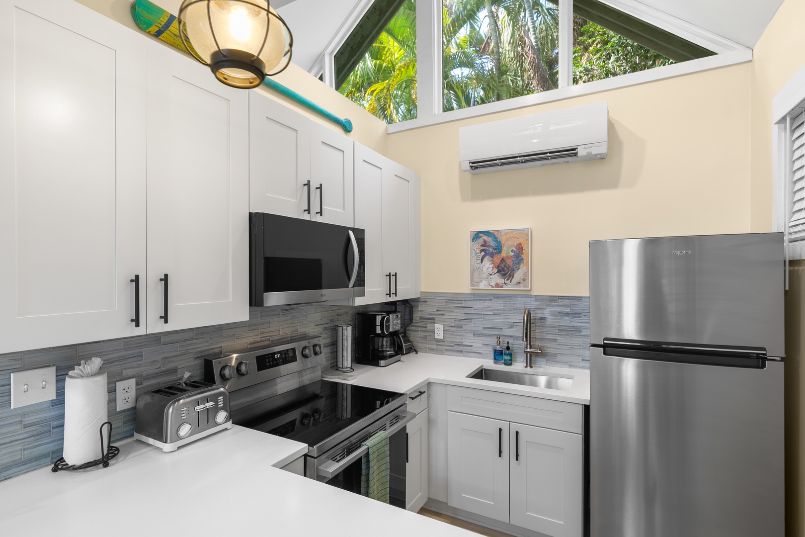 Your bright, fully equipped kitchen features stainless appliances, vaulted ceilings, and a skylight framing lush tropical palms—perfect for cooking in paradise.