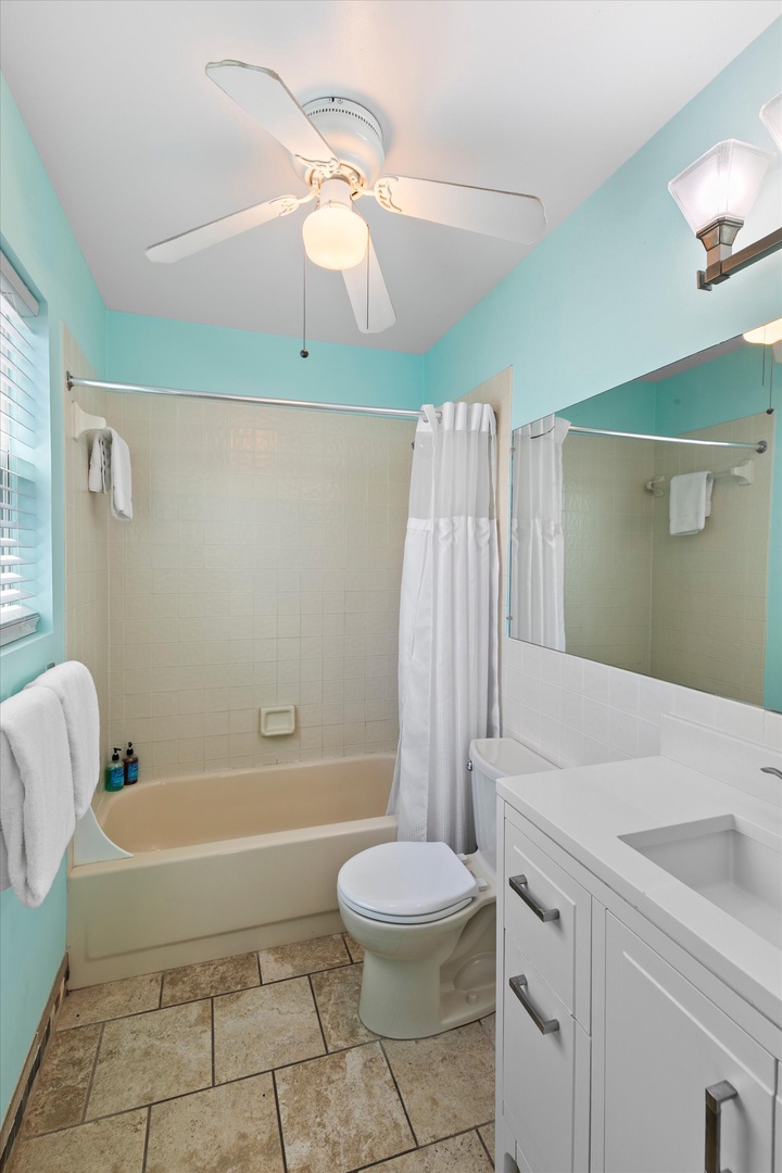 Step into your private bathroom where refreshing aqua walls and crisp white linens create a clean, inviting space. The full tub-shower combo awaits your relaxation after a day of adventure.