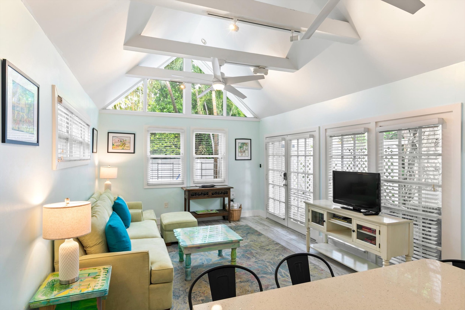 Relax in your bright, airy living room with soaring vaulted ceilings and ceiling fan. Large windows flood the space with natural light while you unwind on the plush sectional or enjoy your favorite shows.