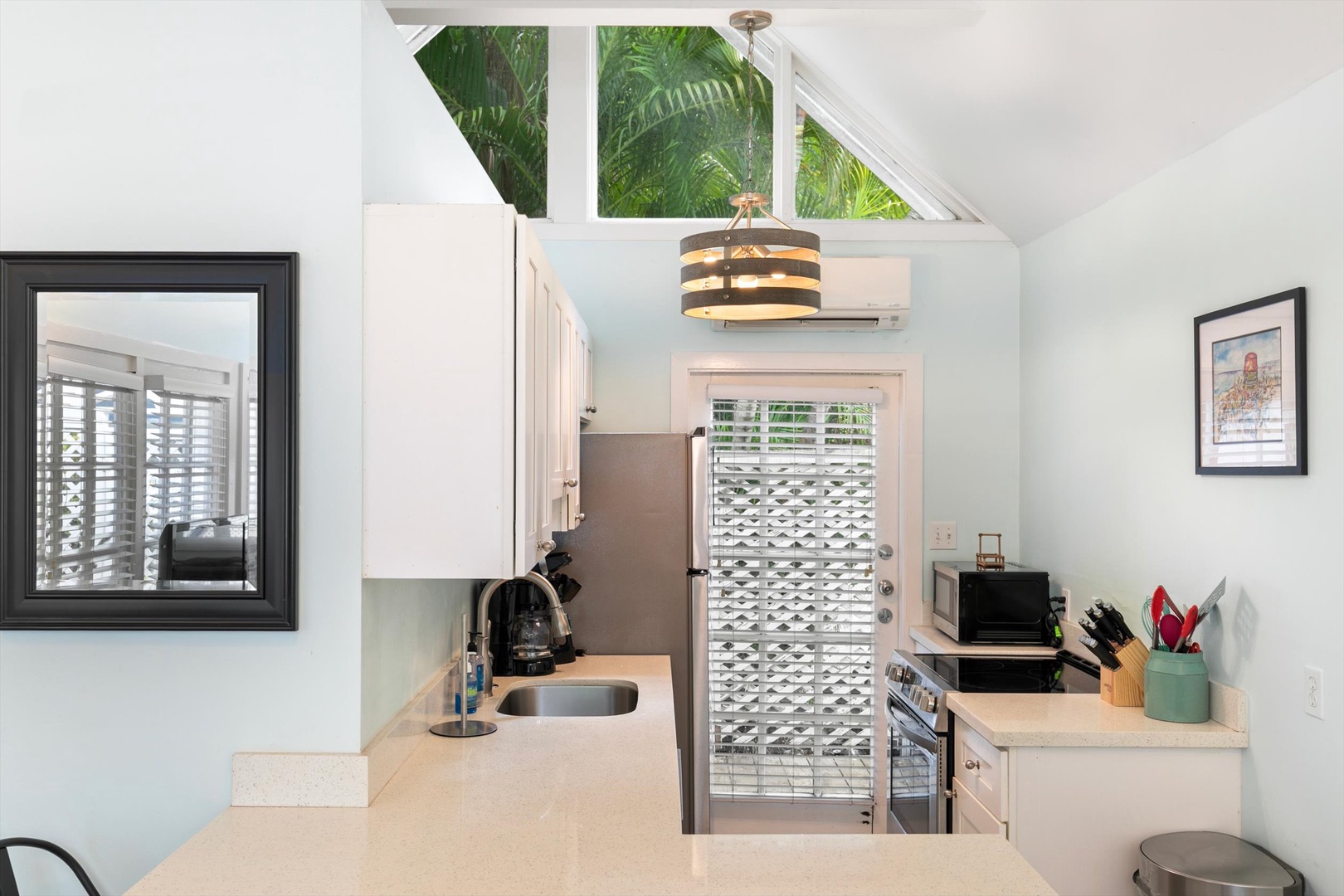 Your private kitchen features stainless steel appliances, generous counter space, and skylights framing lush tropical palms overhead.