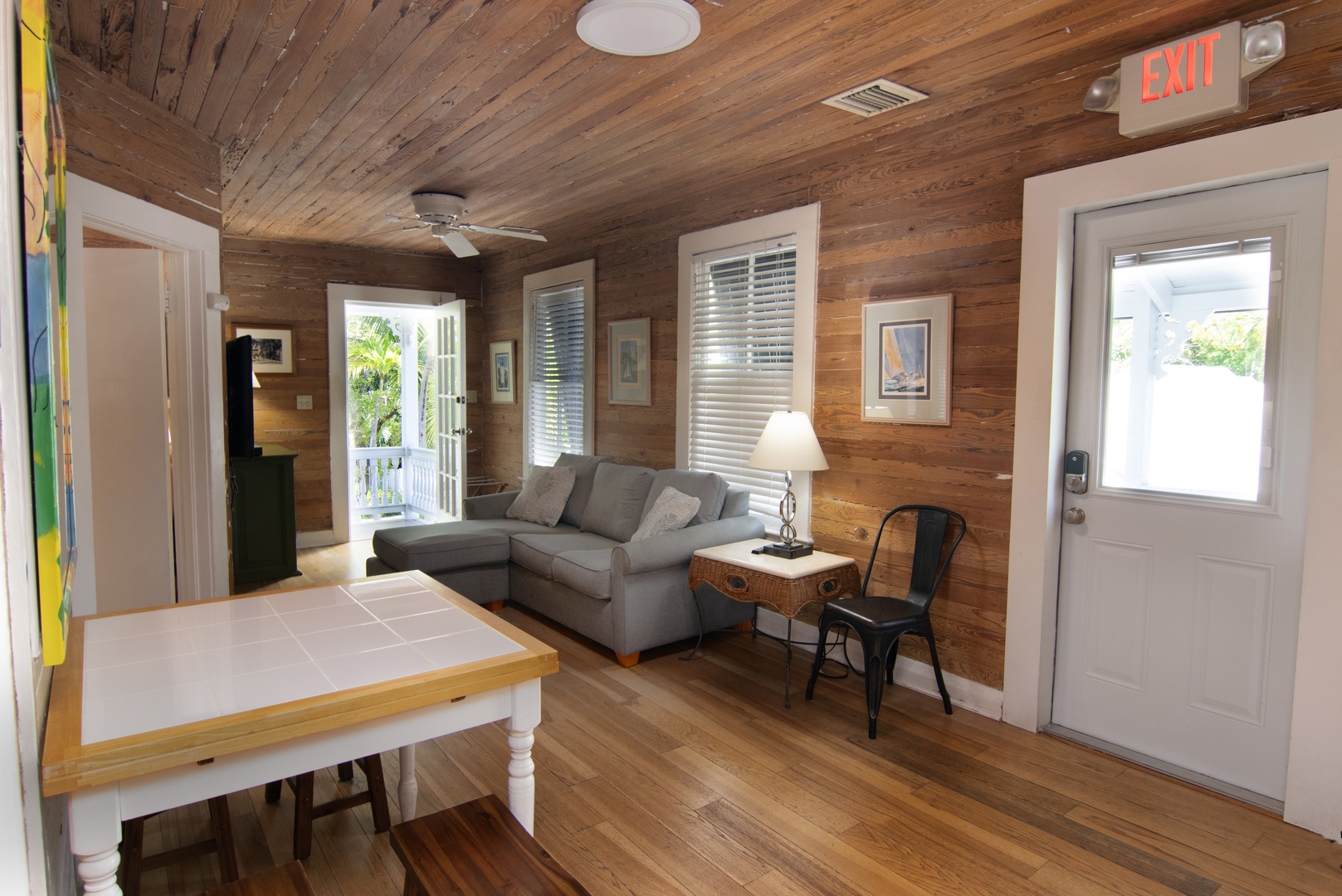 Living room with door to front covered balcony porch with seating