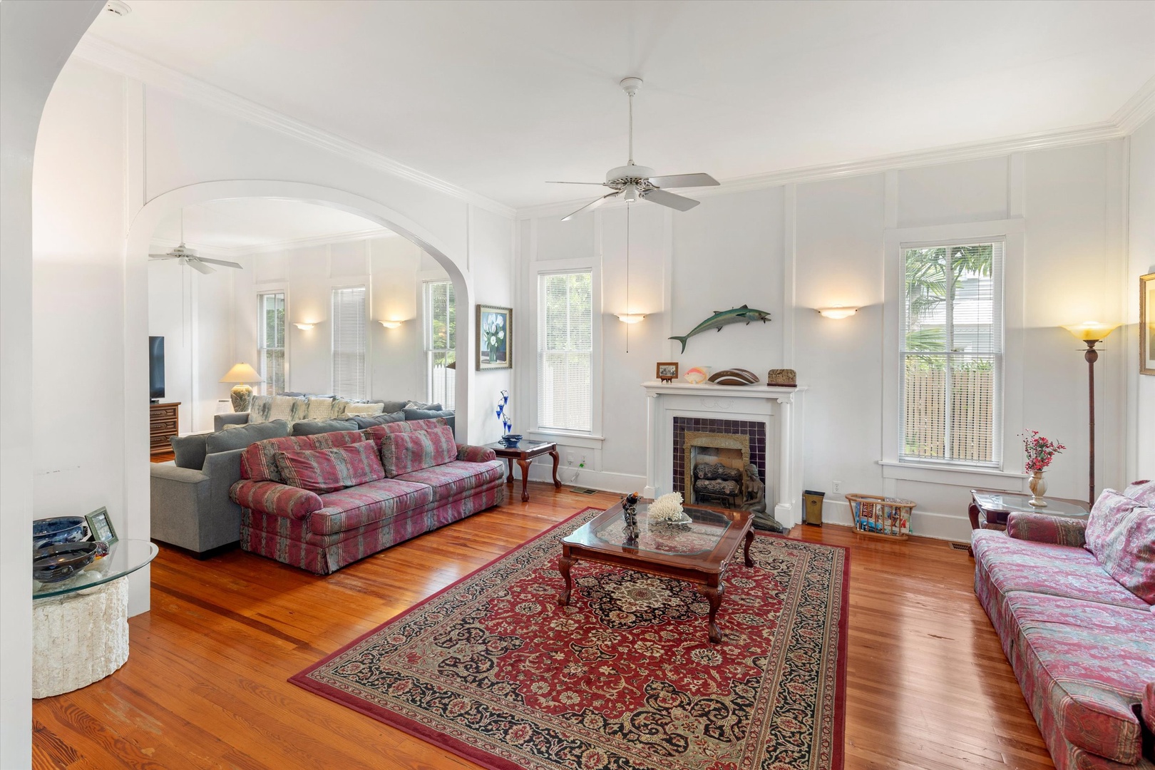 Relax in your spacious living room with gleaming hardwood floors, cozy fireplace, and charming architectural details that invite conversation and comfort after a day of exploring.