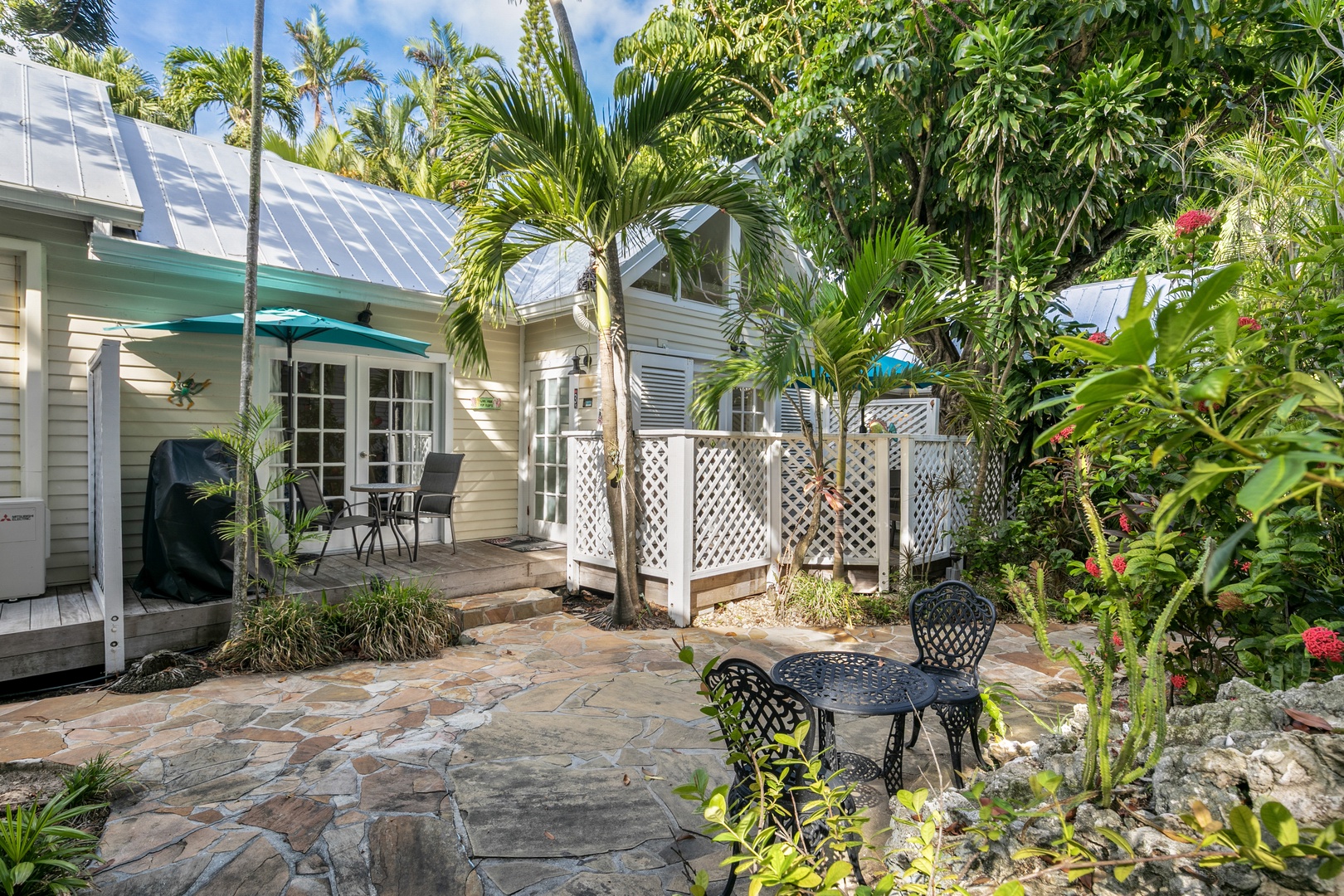 A charming coastal cottage nestled in lush tropical gardens, featuring a private patio where you can enjoy morning coffee surrounded by swaying palms and vibrant greenery.