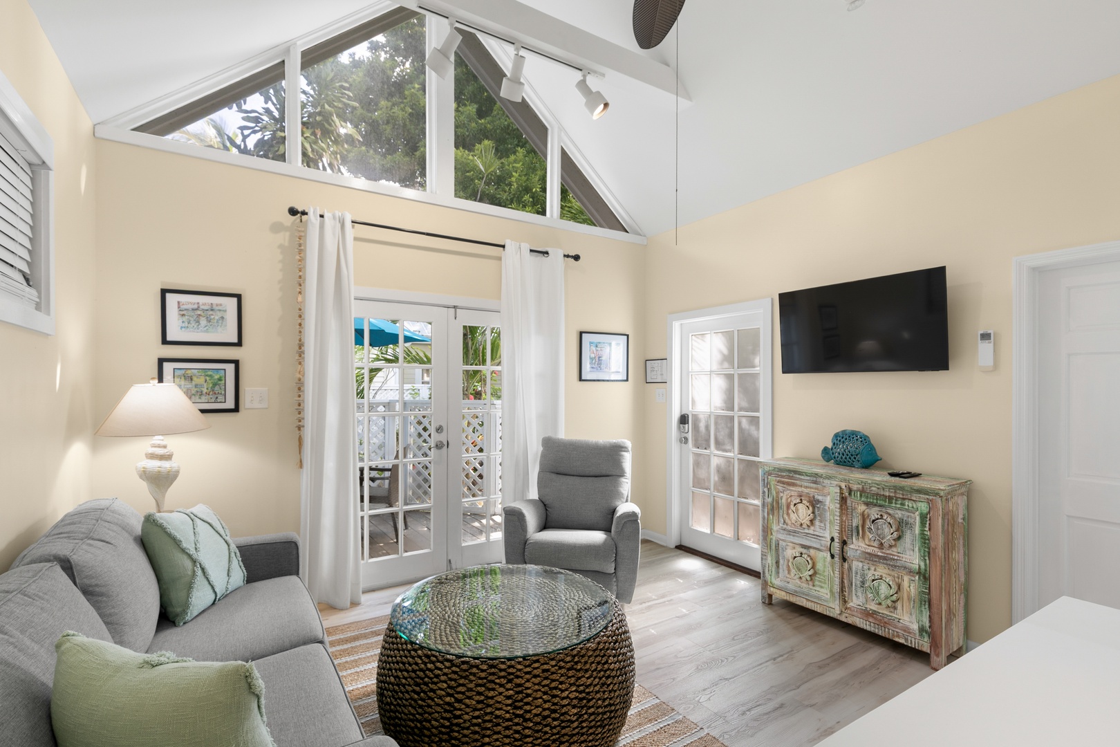 Step into your bright, airy living space where vaulted ceilings and palm-tree views create a peaceful retreat. Sink into the cozy seating and let the tropical vibes welcome you home.