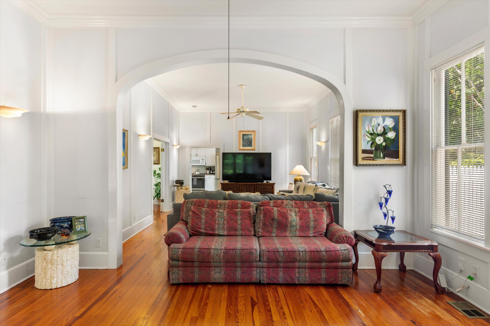 Step into your bright, open living space where elegant archways, warm wood floors, and classic furnishings create a welcoming retreat for relaxing after exploring the area.