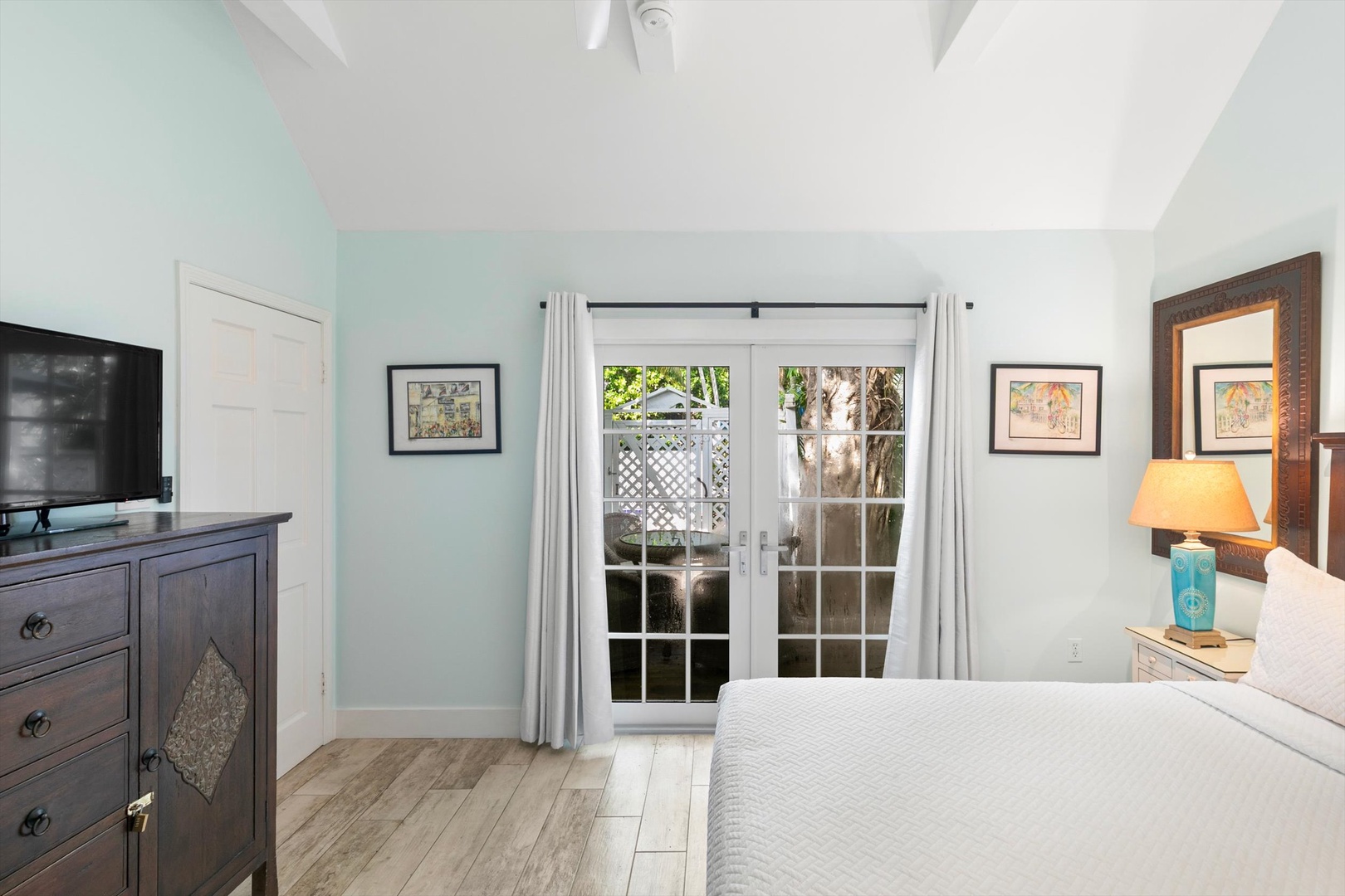 Your peaceful retreat features soft coastal hues, comfortable bedding, and French doors opening to your own private outdoor space where tropical palms greet you each morning.