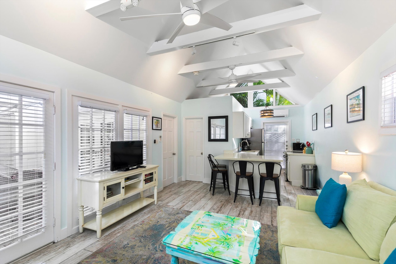 Step into your bright, open-plan retreat where vaulted ceilings and fresh tropical breezes create an instantly relaxing atmosphere. Your cozy living space flows into a dining area and kitchenette, perfect for easy vacation mornings.