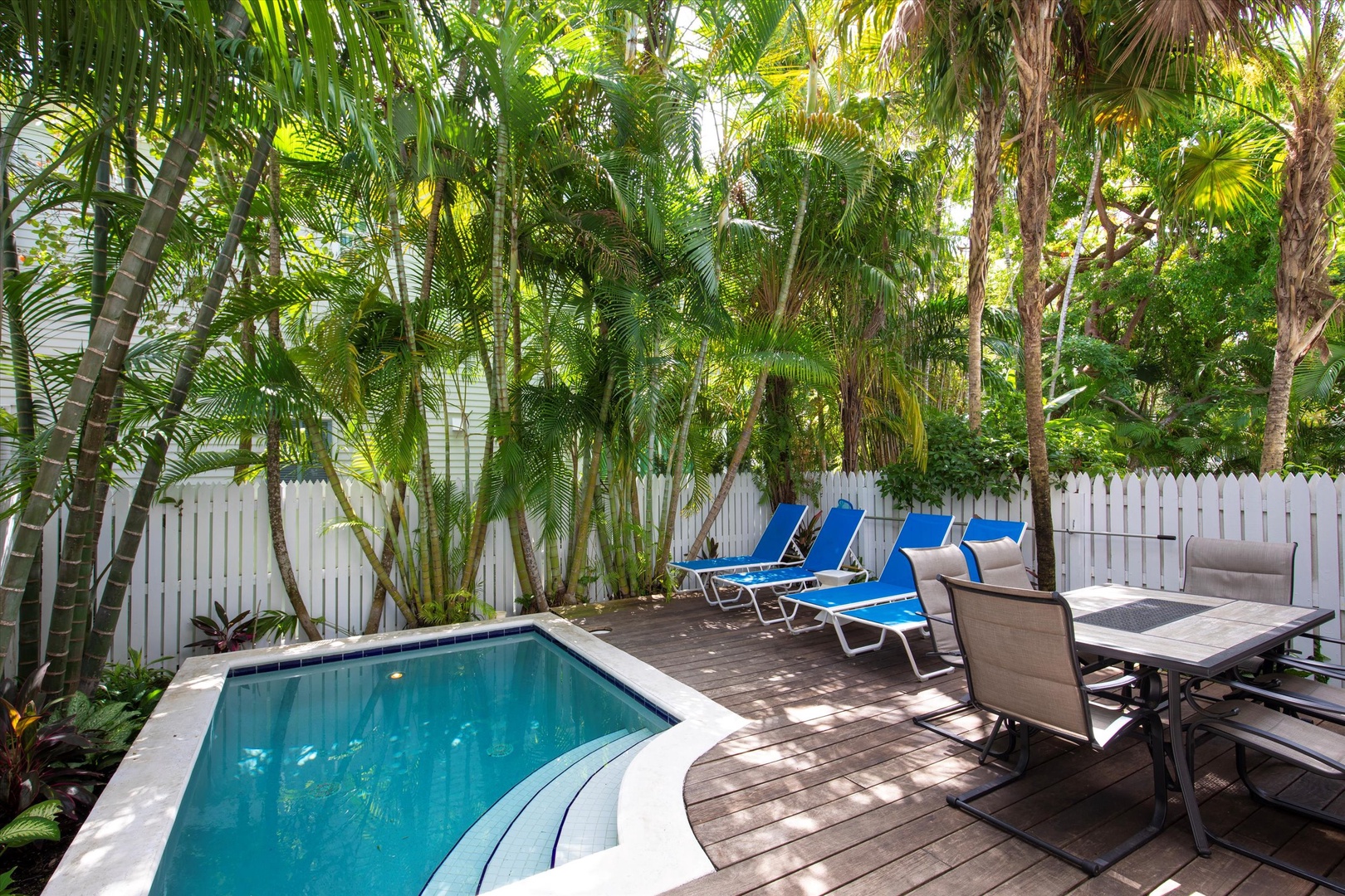 Pool deck with lounge chairs and outside dining area - heated pool