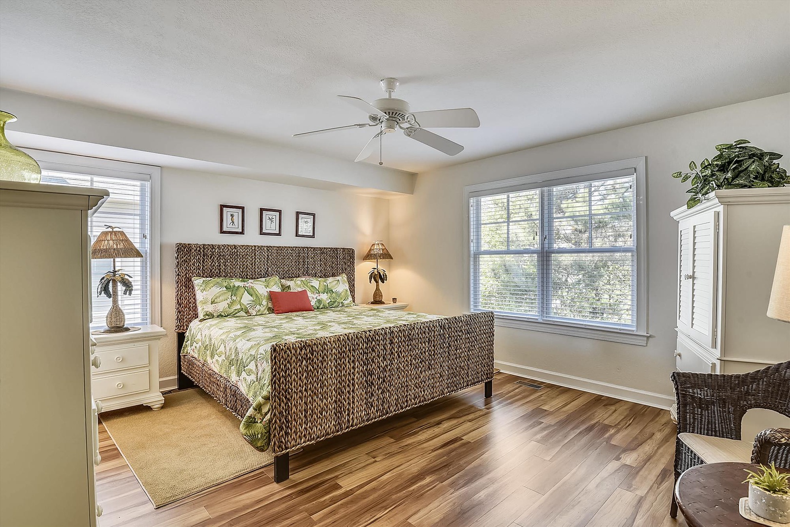 Sink into your tropical island dreams in this serene bedroom, where natural textures and lush greenery create a calming retreat. Ceiling fan keeps you cool while you rest.
