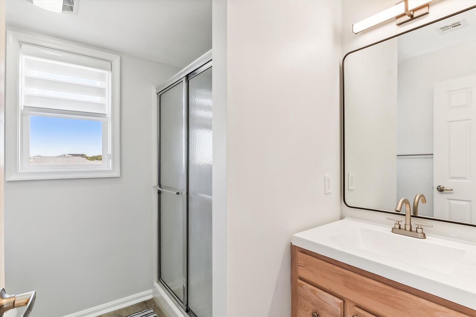 Step into a bright, clean bathroom with modern finishes. Natural light fills the space, highlighting the sleek fixtures and walk-in shower that make your morning routine feel effortless.