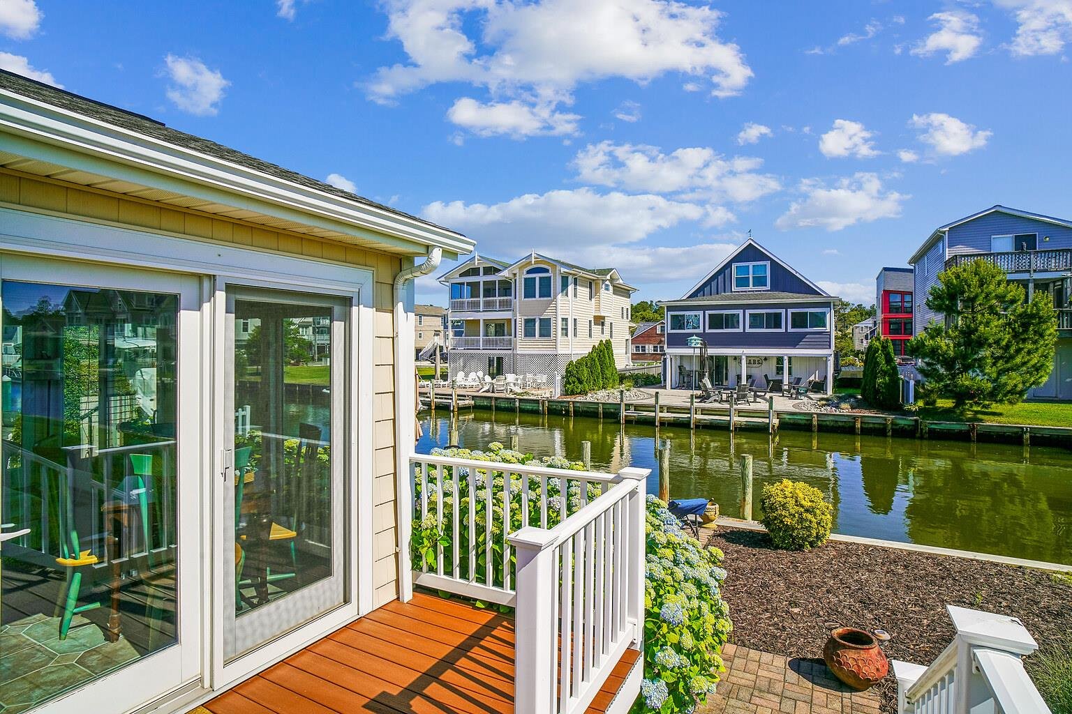 A charming waterfront community where your vacation home sits along a peaceful canal with private dock access and colorful neighboring houses creating a welcoming coastal retreat.