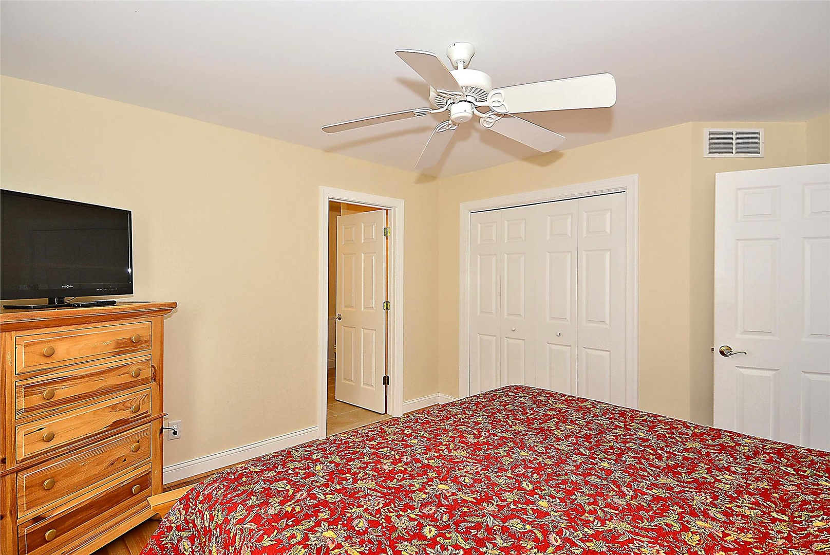 Your cozy bedroom features a plush bed, warm hardwood floors, and a ceiling fan to keep you comfortable. Ample closet space and entertainment await in this inviting retreat.