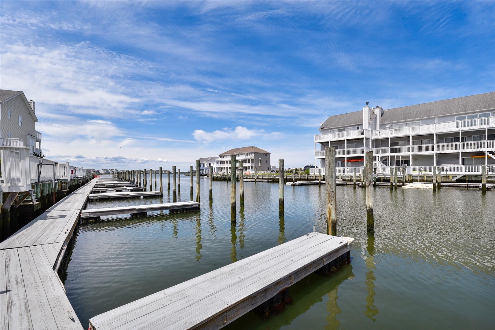 Waterfront marina with private boat slips surrounded by coastal residential buildings, located within the property's neighborhood area.