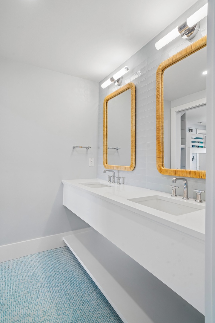 Your bright, modern bathroom features dual vanities and coastal-inspired accents that create a serene, spa-like retreat.