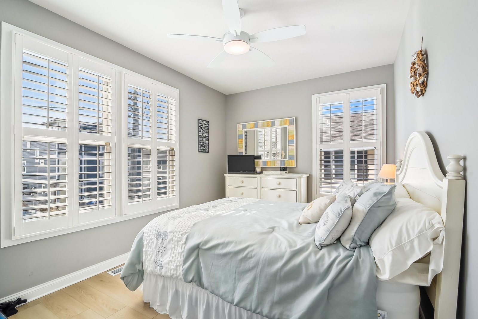 Sink into the plush bedding and let the gentle ceiling fan breeze lull you to sleep in this serene coastal retreat.