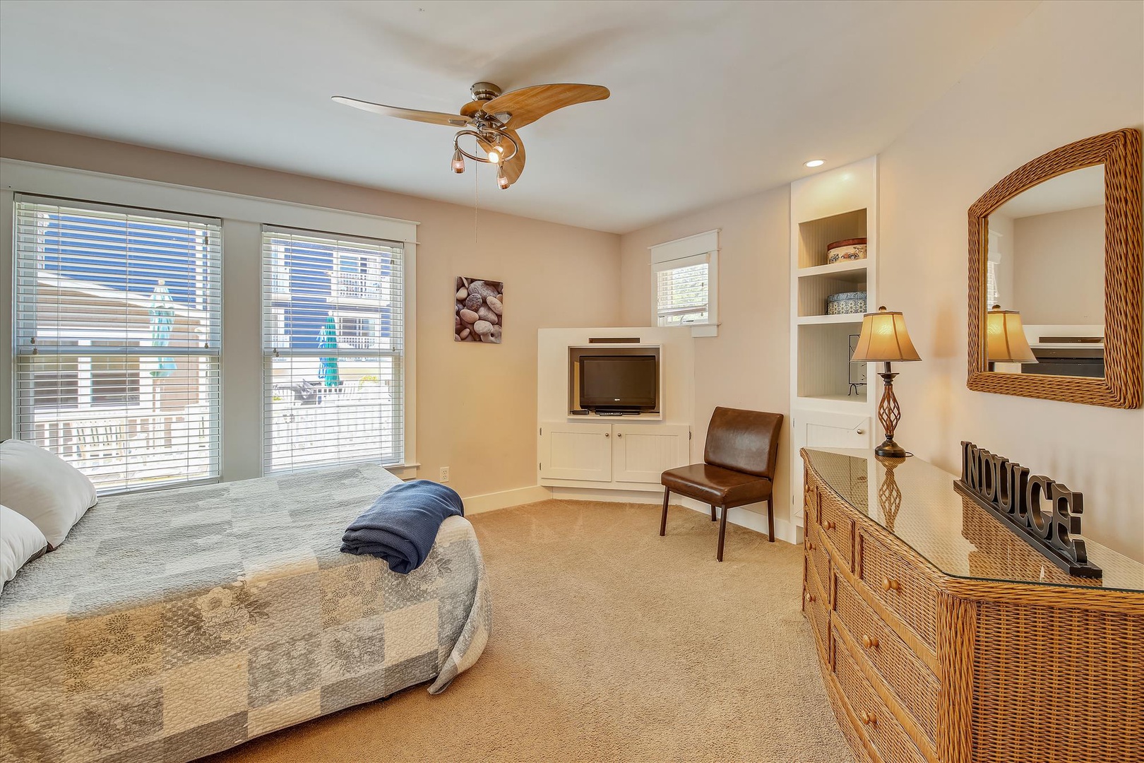 Your coastal-themed bedroom offers a cozy retreat with a ceiling fan to keep you cool, built-in shelves for your belongings, and comfortable seating to unwind after a day of beachside adventures.