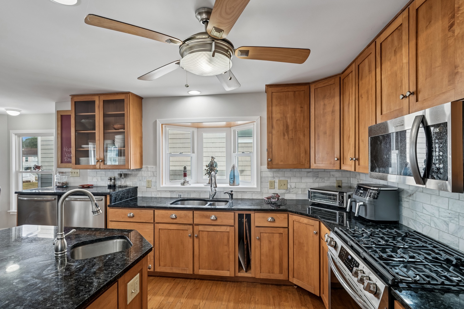 Cook your favorite meals in this fully-equipped kitchen featuring granite countertops, stainless steel appliances, and warm wood cabinetry.