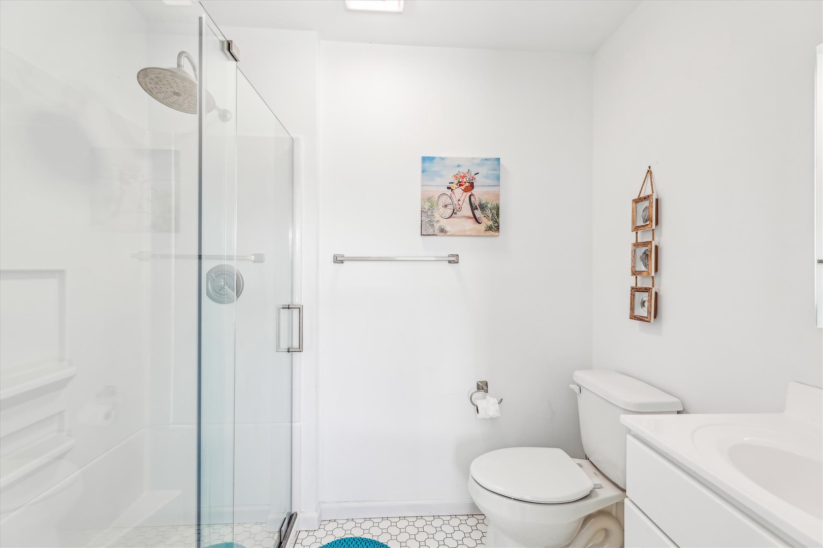 Step into your pristine, spa-like bathroom where bright natural light and clean white surfaces create a refreshing retreat. The walk-in shower and elegant fixtures make every morning feel rejuvenating.