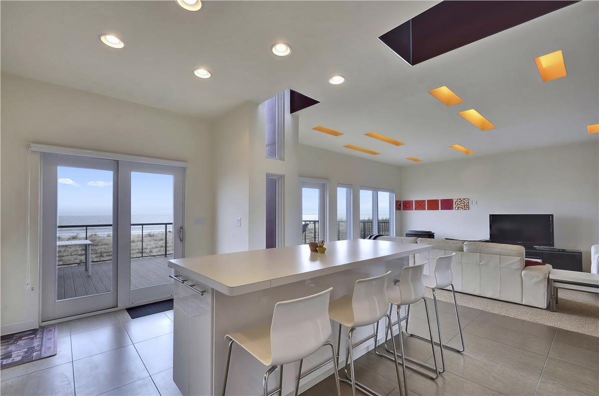 This modern open-concept space blends your kitchen, dining, and living areas into one bright, welcoming retreat with ocean views just beyond the deck.