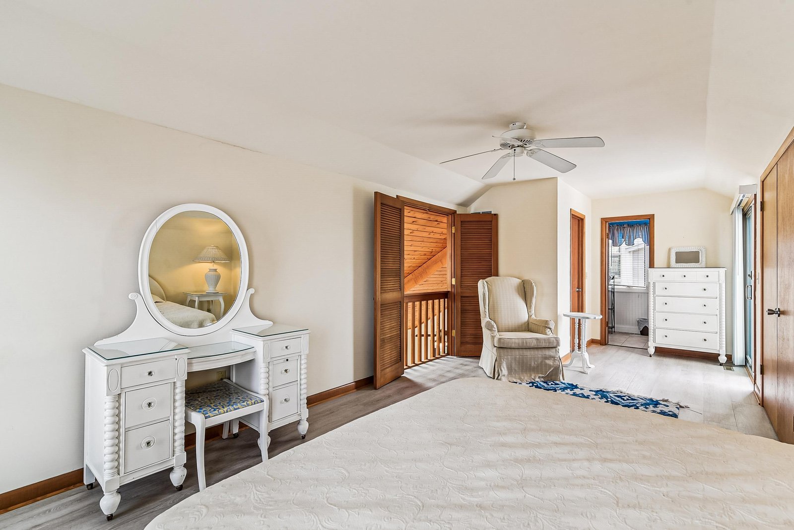Step into your bright, airy bedroom where soft linens and a gentle overhead fan await. Classic details and plenty of natural light create a peaceful, welcoming retreat.