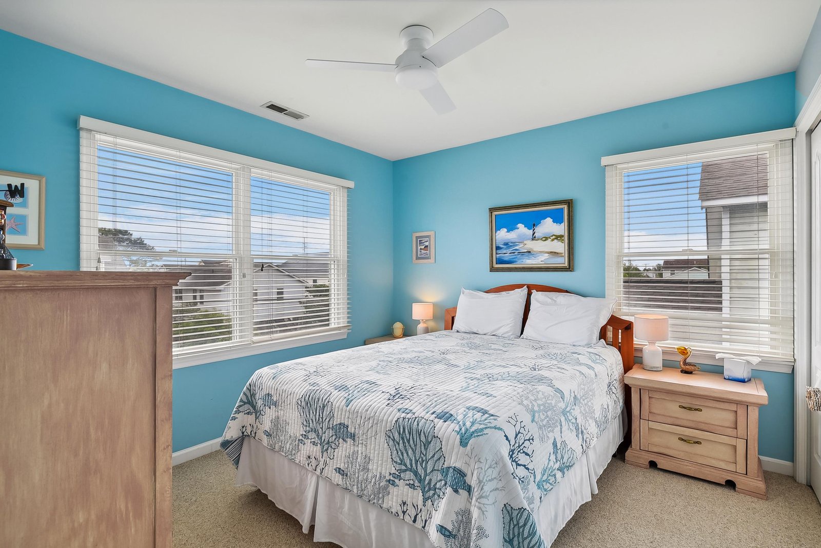 Wake up to coastal charm in this cheerful bedroom, where calming blue walls and ocean-themed accents create your peaceful retreat after days of adventure.