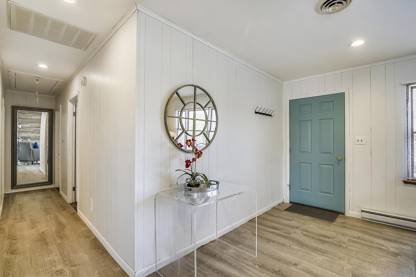 Step into your peaceful retreat through this bright, welcoming entryway. Clean white shiplap walls and modern touches create a calming first impression as you arrive.