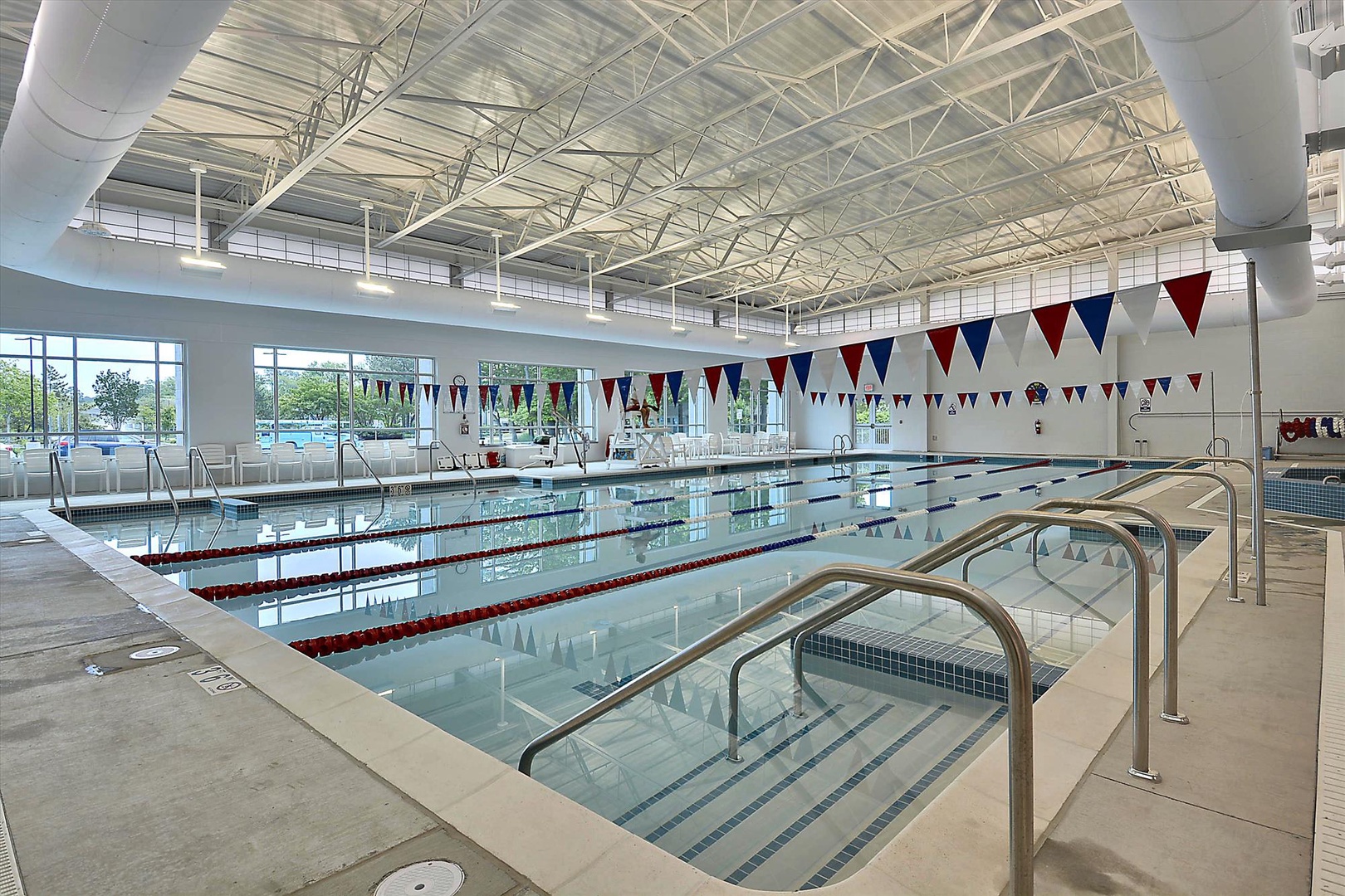 Modern indoor pool with lap lanes and festive bunting, perfect for year-round swimming and aquatic exercise, no matter the weather outside.