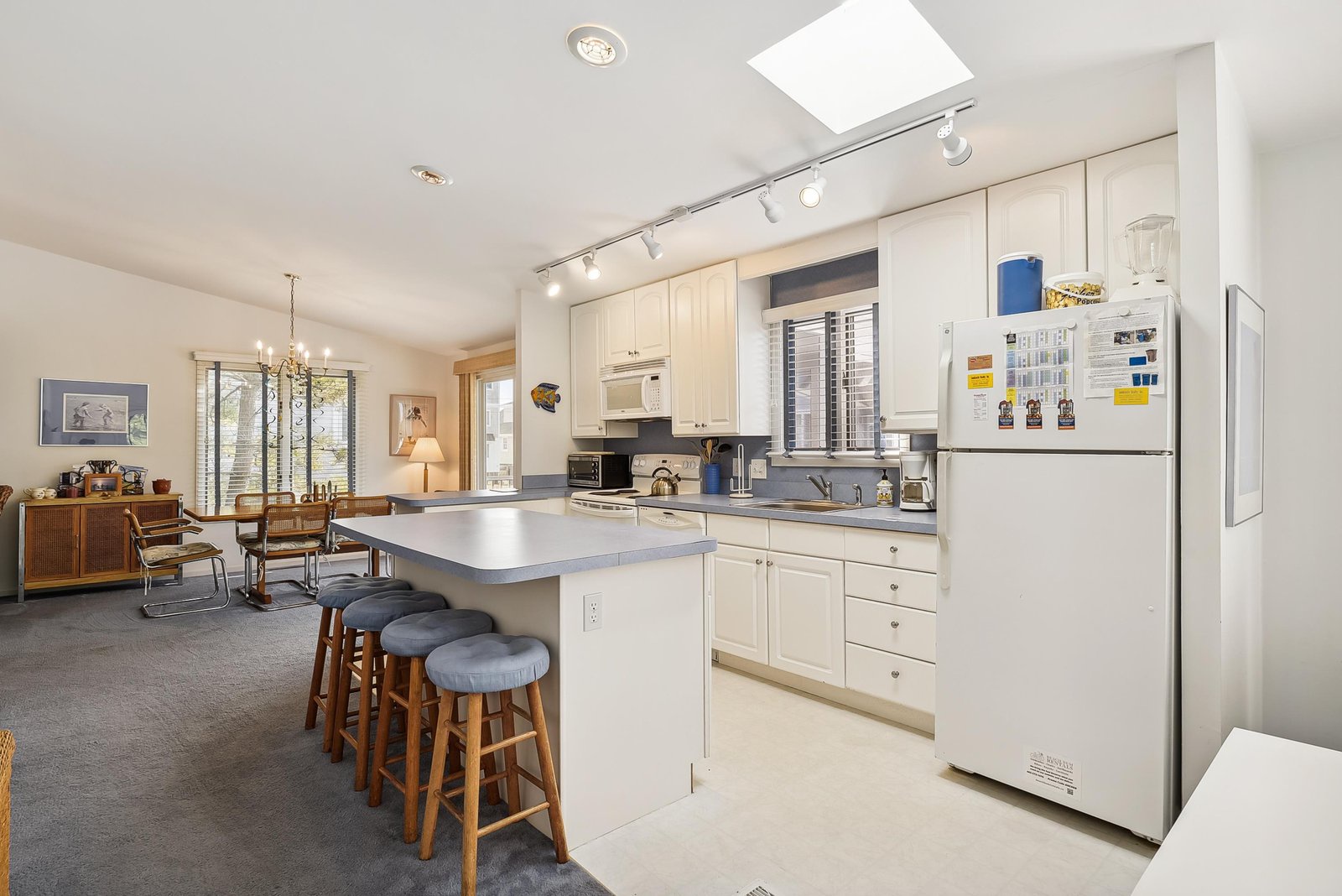 Step into your open-concept kitchen, where natural light pours in through the skylight above your island. Cook and gather around the breakfast bar, all while staying connected to the inviting dining area just beyond.